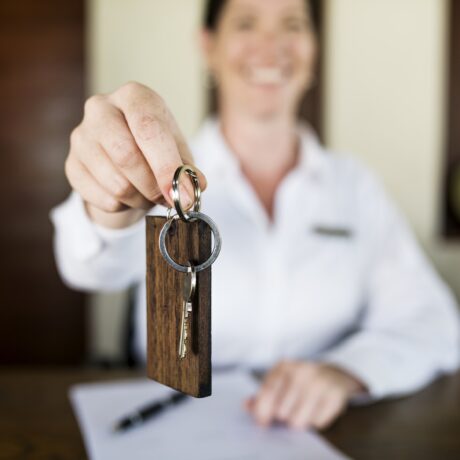 Receptionist handing room key to guest